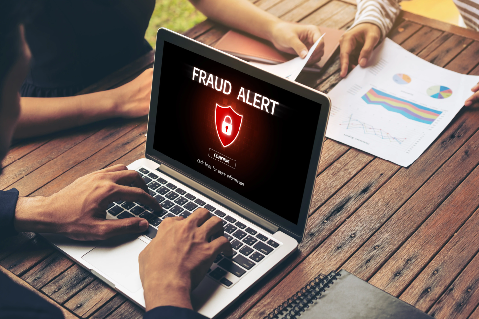 A digital padlock on a laptop screen representing strategies for preventing digital scams in businesses.